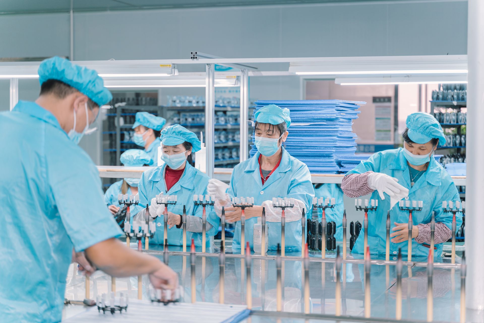 Operators in cleanroom suits loading parts